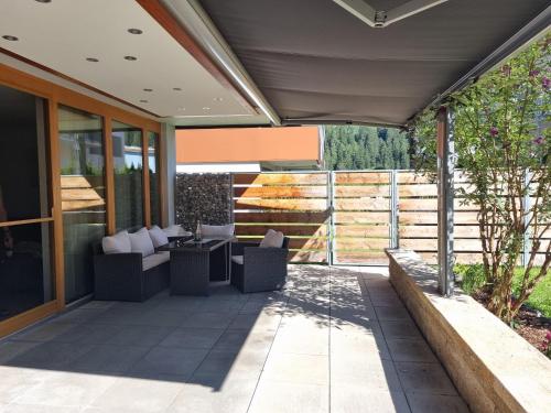 a patio with two chairs and a table on it at Alpine Hideaway in Arzl im Pitztal