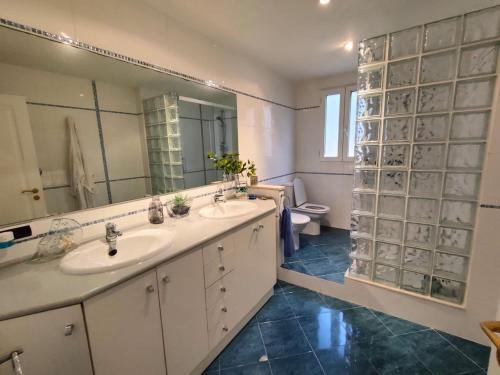 a bathroom with two sinks and a mirror and a toilet at Precioso chalet 4 habitaciones con Piscina comunitaria in Benicàssim