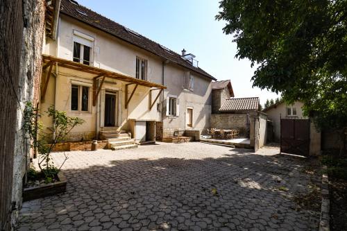 an empty courtyard of a house with a building at Les crins du vignoble in Loches-sur-Ource