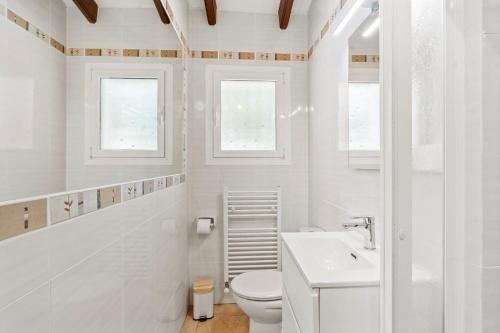 ein weißes Badezimmer mit Toilette und Waschbecken in der Unterkunft Villa Sunset Moraira mit eigenem Pool, Strandnähe, Klimaanlage, Heizung, Outdoor-Küche, Grill in Teulada