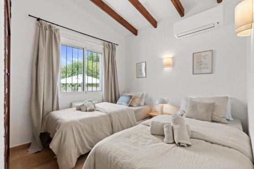 zwei Betten in einem Zimmer mit Fenster in der Unterkunft Villa Sunset Moraira mit eigenem Pool, Strandnähe, Klimaanlage, Heizung, Outdoor-Küche, Grill in Teulada