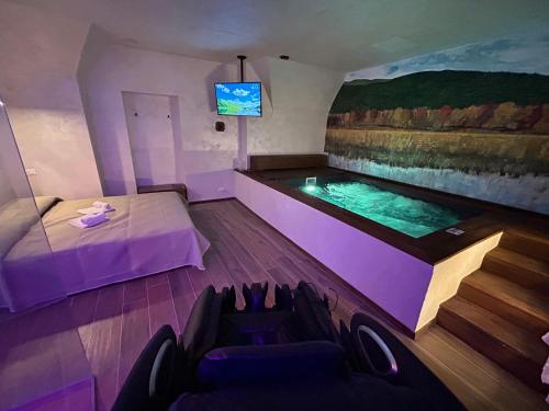 a room with a swimming pool and a tv at Suite del Lago LuxuryRoom in Biccari