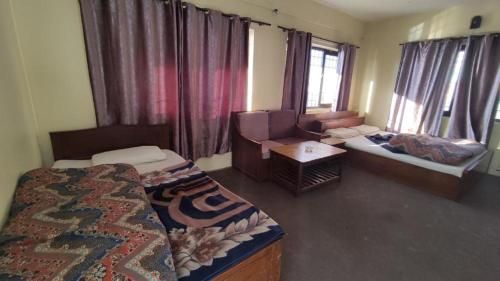 une chambre avec deux lits, un canapé et une table dans l'établissement Tanveer Hotel, à Dargai