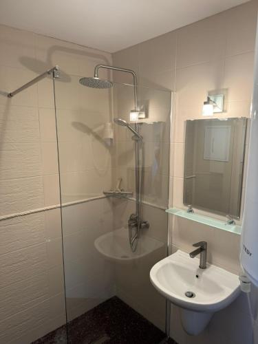 a bathroom with a sink and a glass shower at Villa Rada, Bay View Villas in Kosharitsa