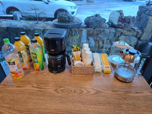 a table with a coffee maker and bottles on it at Cheonjiyeon Hotel in Seogwipo