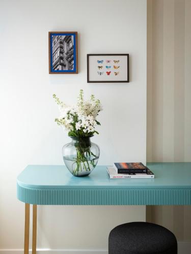 a blue table with a vase of flowers on it at Taksim Juno Residences in Istanbul