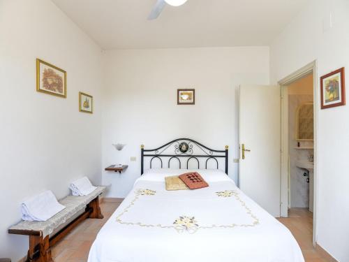 a white bedroom with a bed and a bench at Tranquil Stay in Montepulciano in Acquaviva