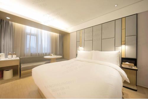 a bedroom with a large white bed and a couch at JI Hotel Beijing Shangdi Anningzhuang in Beijing