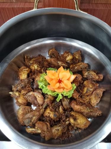 LhokseumaweにあるHotel Dianaの上に花が飾られた鍋料理