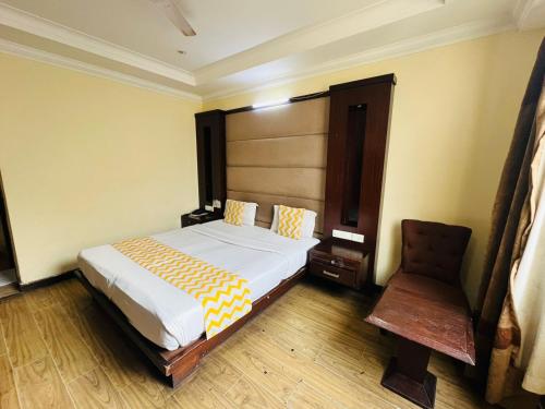 a bedroom with a bed and a chair in it at Hotel Imperial Inn - Nehru Place in New Delhi
