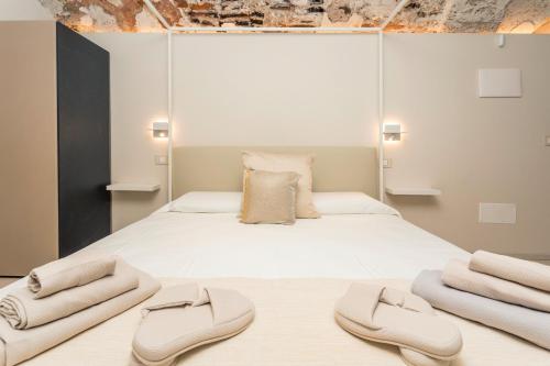 a bedroom with a large white bed with two slippers at Spazio Pardo in Catania