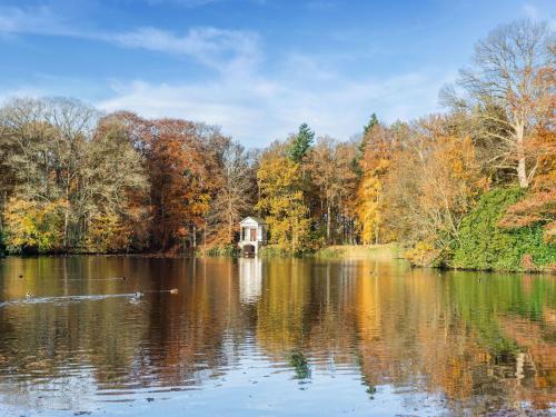 a lake with a house in the middle of it at Holiday home Het Zuidgoed with garden in Aartrijke