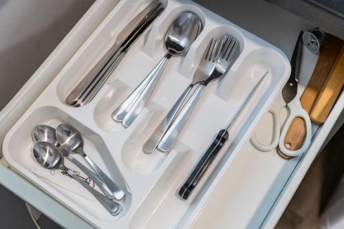 a white tray with silver utensils on it at Svečių namai Imperija in Šiauliai
