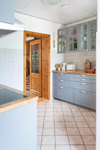 a kitchen with blue cabinets and a tile floor at Elbwiesenhaus-an-der-Elbe in Lenzerwische