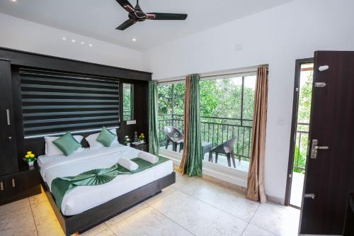 a bedroom with a bed and a balcony at Moonveil Premium Villa Munnar in Anachal