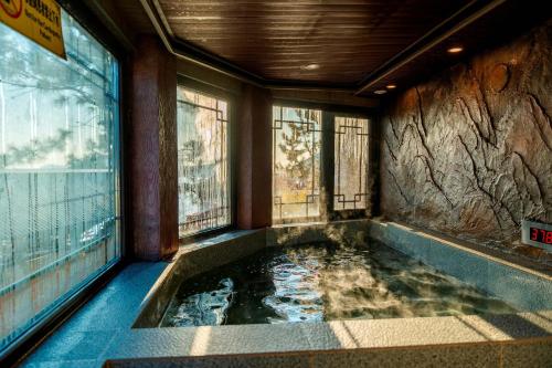 青島市にあるLaoshan Swan Castle Immortal Residence bathing pool Health Garden B&Bの窓のある部屋にあるジャグジー浴槽