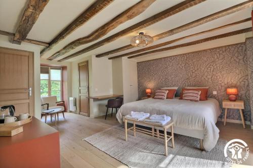 a bedroom with a large bed and a table at Le jardin de quercus in Bazouges-la-Pérouse