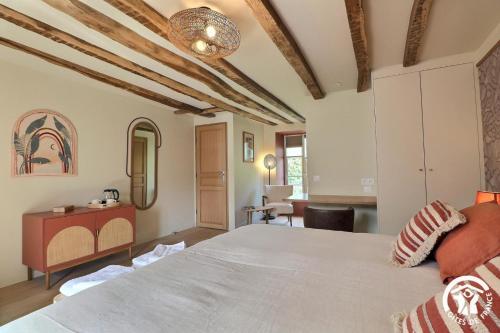 a bedroom with a large bed in a room at Le jardin de quercus in Bazouges-la-Pérouse