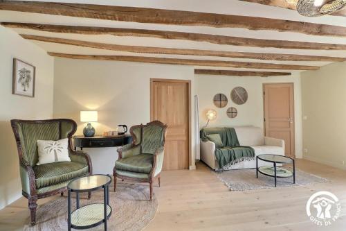 a living room with two chairs and a couch at Le jardin de quercus in Bazouges-la-Pérouse