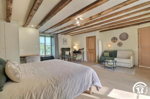a bedroom with a bed and a living room at Le jardin de quercus in Bazouges-la-Pérouse