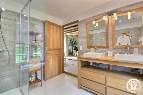 a bathroom with two sinks and a shower at Le jardin de quercus in Bazouges-la-Pérouse