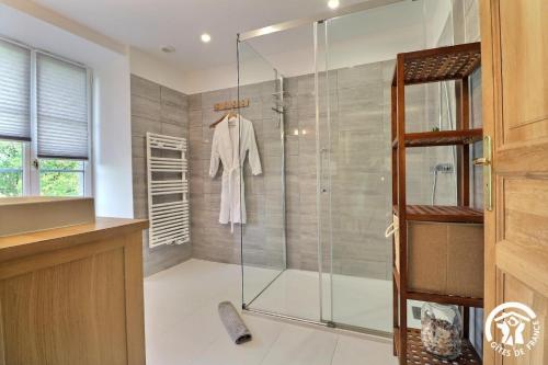 a bathroom with a shower with a glass door at Le jardin de quercus in Bazouges-la-Pérouse