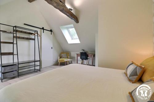 a bedroom with a large bed and a desk at Le jardin de quercus in Bazouges-la-Pérouse
