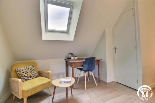 a living room with a chair and a table at Le jardin de quercus in Bazouges-la-Pérouse