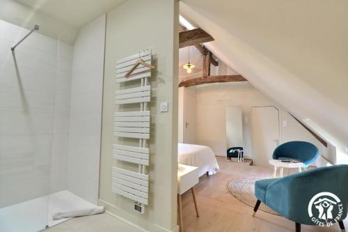 a bedroom with a bed and a bathroom with a sink at Le jardin de quercus in Bazouges-la-Pérouse