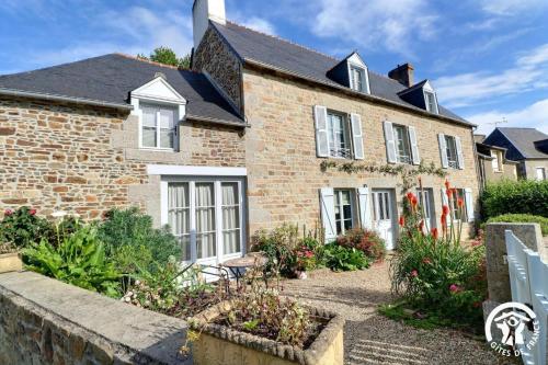 an old brick house with a garden in front of it at Le jardin de quercus in Bazouges-la-Pérouse