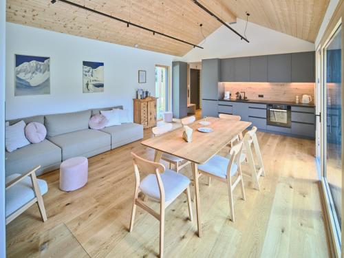 a kitchen and living room with a wooden table and chairs at Chalet Hochsteiermark in Mariazell