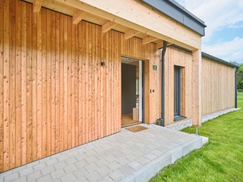 a house with a wooden wall and a patio at Chalet Hochsteiermark in Mariazell