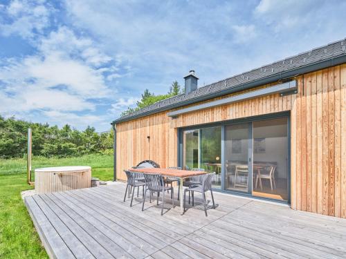 a wooden deck with a table and chairs on it at Chalet Hochsteiermark in Mariazell