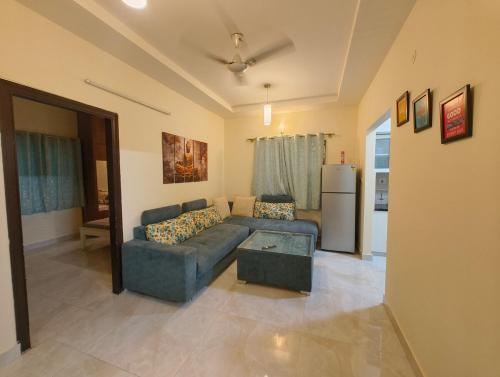a living room with a couch and a refrigerator at M's Cozy Unwind - Hazel in Bengaluru
