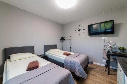 a room with two beds and a clock on the wall at Svečių namai Imperija in Šiauliai