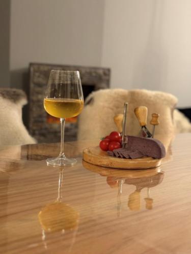 a glass of wine and a plate of food on a table at Boris’s Guest Apartment in Chepelare