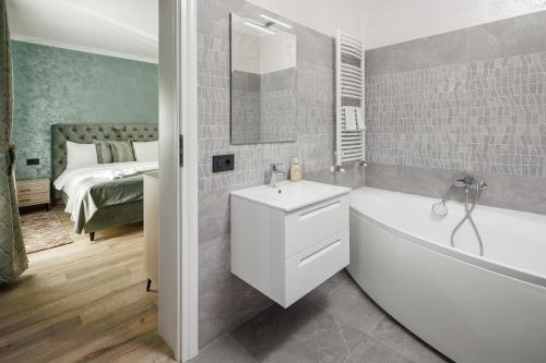 Un baño con un lavabo blanco y una bañera y una cama. en Vista Valley Resort, en Zărneşti