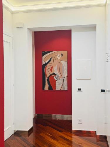 a painting of a woman on a red wall in a room at B&B Amo' in Forlì