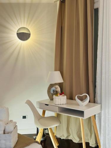 a table with a lamp and a chair in a room at B&B Amo' in Forlì