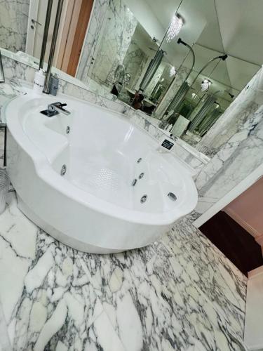 a white bath tub in a bathroom with marble floors at B&B Amo' in Forlì