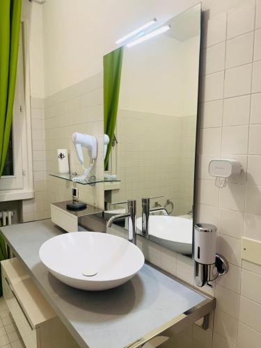 a bathroom with a white sink and a mirror at B&B Amo' in Forlì