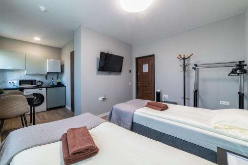 a hotel room with two beds and a kitchen at Svečių namai Imperija in Šiauliai