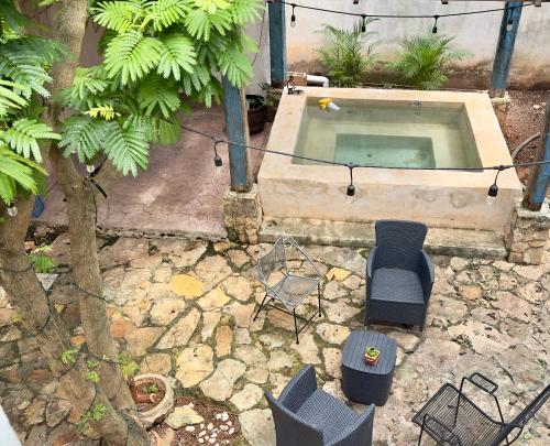 an overhead view of a pool with chairs and a tree at Casa La Perla del Sur Confort y calidez en todos sus espacios in Ticul