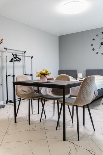 a dining room with a black table and chairs at Svečių namai Imperija in Šiauliai