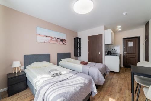 a hotel room with two beds and a kitchen at Svečių namai Imperija in Šiauliai