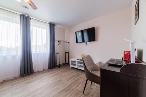 a living room with a desk and a tv on the wall at Svečių namai Imperija in Šiauliai