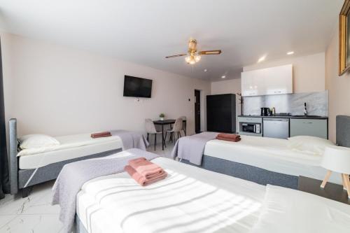 a room with three beds and a kitchen at Svečių namai Imperija in Šiauliai