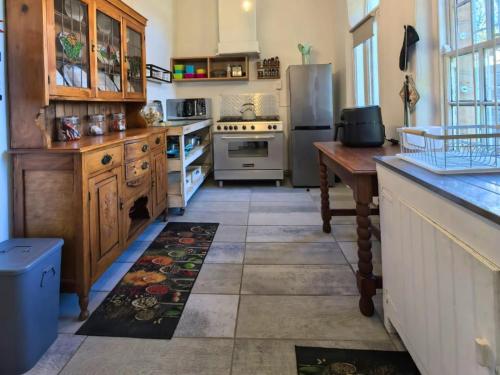 a kitchen with a refrigerator and a table in it at La Petite Maison de Grès in Fouriesburg