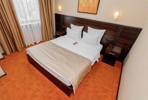 a bedroom with a large bed with white sheets and pillows at Best Western Plus Atakent Park Hotel in Almaty
