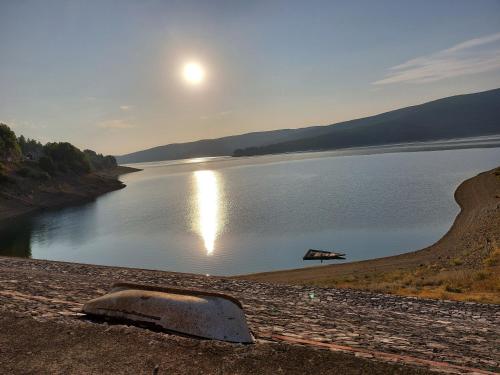 a view of a lake with the sun reflecting on the water at D & O Apartments in Mavrovo
